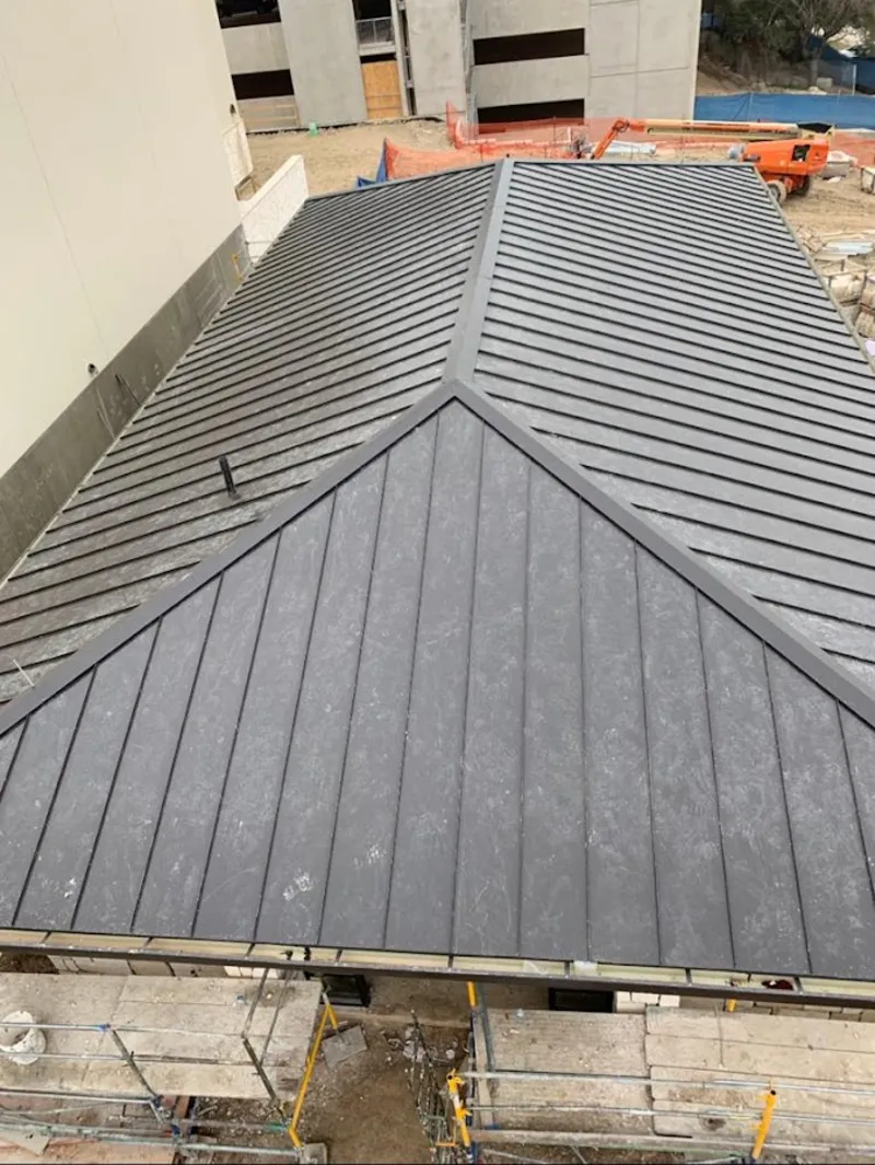 Commercial metal roof construction with crane equipment in Kingsburg
